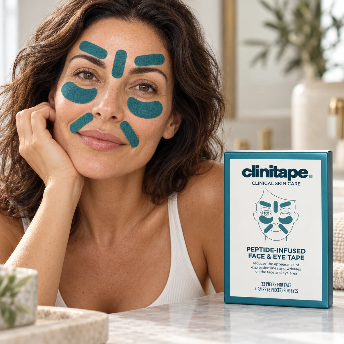 Model wearing seven teal face tapes beside the Clinitape box